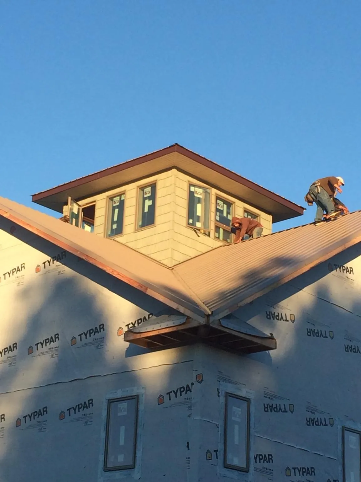 Roofers working around a rooftop cupola on a new metal roof at sunset — Roof Waterproofing in La Grange by Roofing Brothers